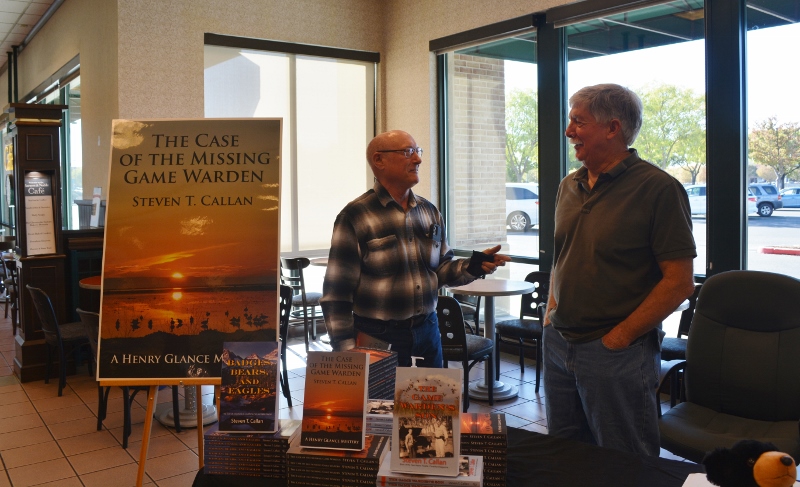Author Steven T. Callan and a friend discuss the author's latest book, The Case of the Missing Game Warden