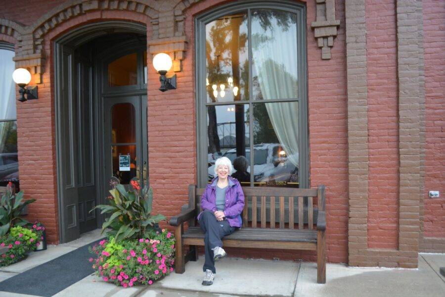Kathy Callan sits in front of the historic Fort Benton Hotel, built in 1882.